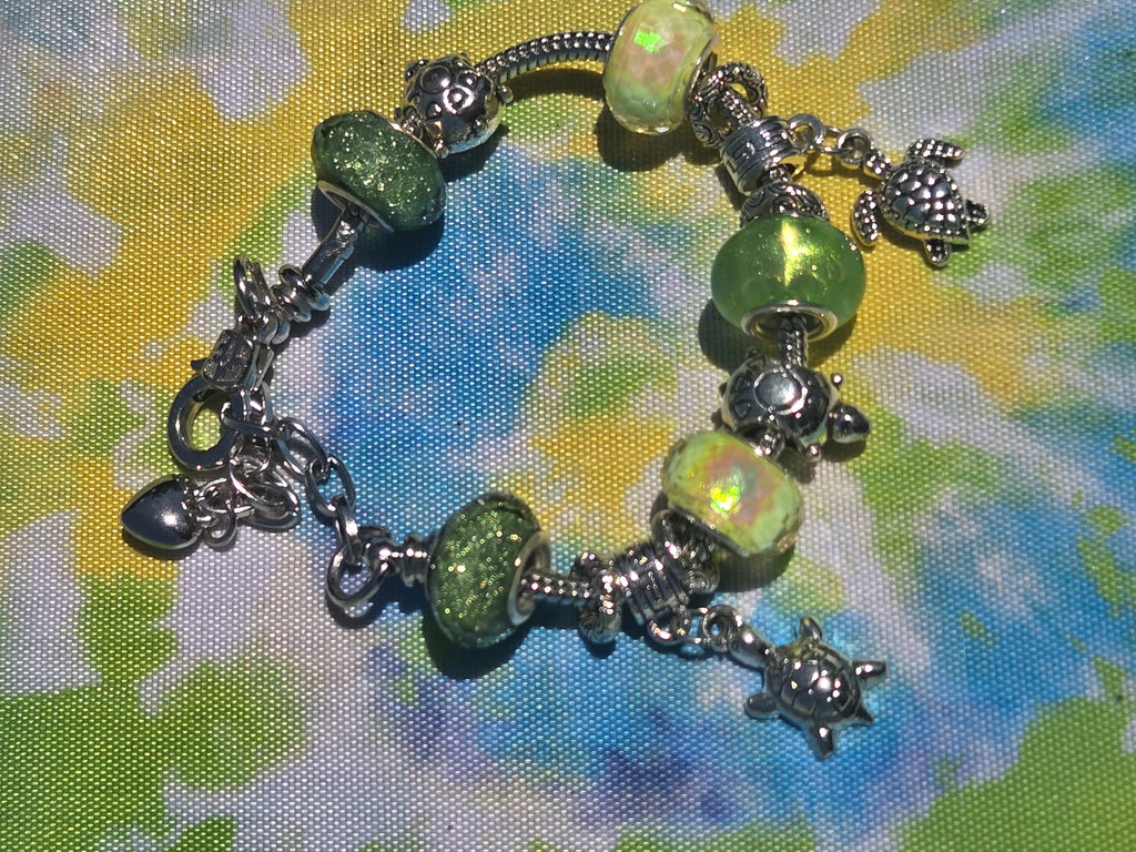 Bracelet with green beads and charms on a patterned background