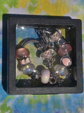 Jewelry set with charms in a clear box on a colorful fabric background